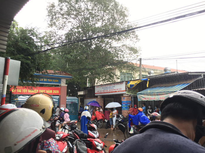Phụ huynh đứng đợi dưới cơn mưa khá lớn