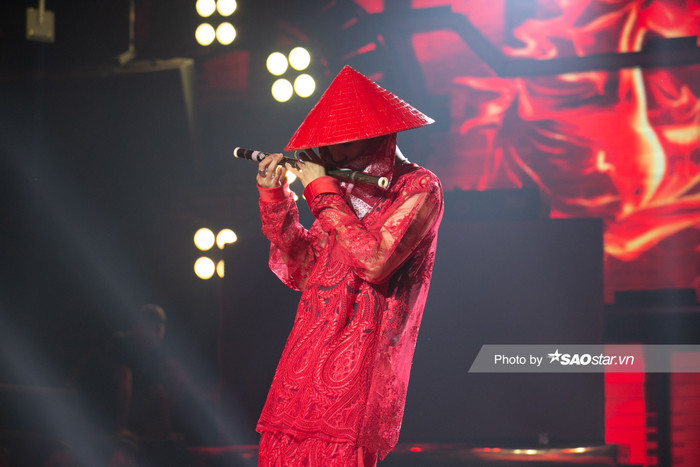 Nón lá truyền thống Việt Nam được anh chàng sơn đỏ để cho tiệp màu với set đồ mà anh mặc 