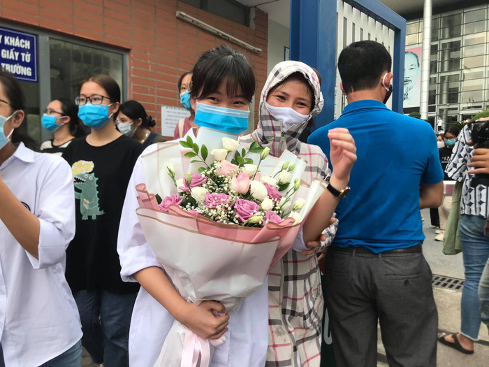 Phụ huynh đứng đợi con em mình, tặng hoa chúc mừng con sau những ngày tháng thi cử vất vả. 