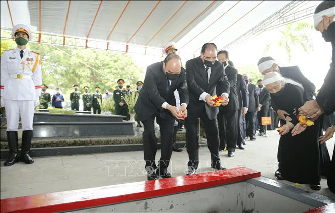 Thủ tướng Nguyễn Xuân Phúc và các đồng chí lãnh đạo Đảng, Nhà nước thực hiện nghi thức thả hoa xuống nơi an táng nguyên Tổng Bí thư Lê Khả Phiêu. Ảnh: Doãn Tấn/TTXVN
