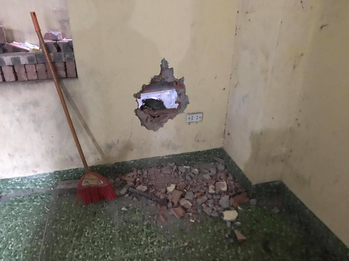 Cảnh sát đục tường giải cứu cháu bé ra ngoài.