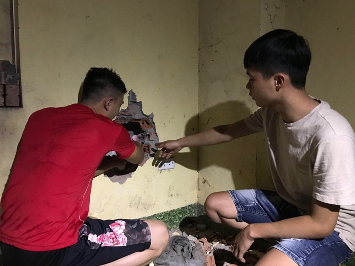 Người dân khoan tường đưa cháu bé ra ngoài.