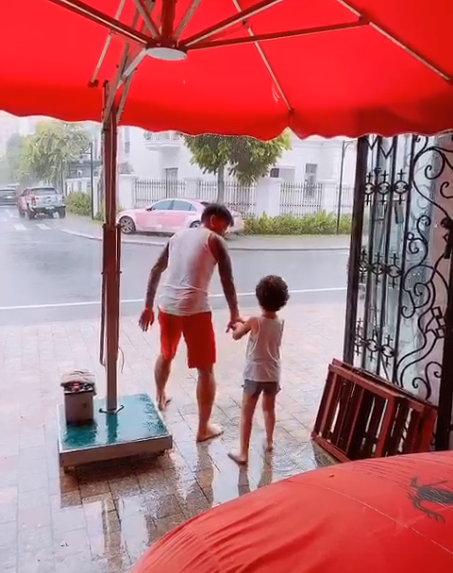 Hương Baby chia sẻ khoảnh khắc ông xã Tuấn Hưng cùng con trai tắm mưa