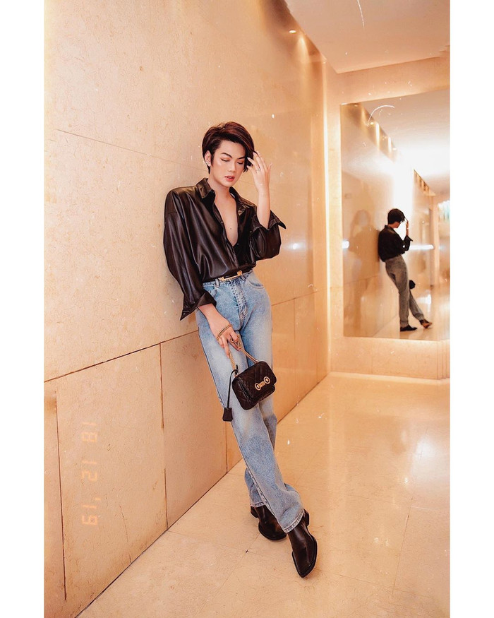 Cũng là áo chemise nhưng chất liệu da bóng đi cùng quần jeans ống đứng và túi nhỏ cầm tay tạo nên vẻ ngoài ấn tượng. 