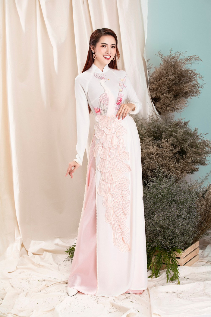 Ngoài ra, sự lựa chọn kiểu áo dài màu hồng pastel ngọt ngào với họa tiết phượng may nổi đầy thu hút 