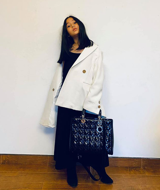 Áo vest phom rộng, chân váy dài và cao gót cùng túi xách sang chảnh không kém cạnh ai. 