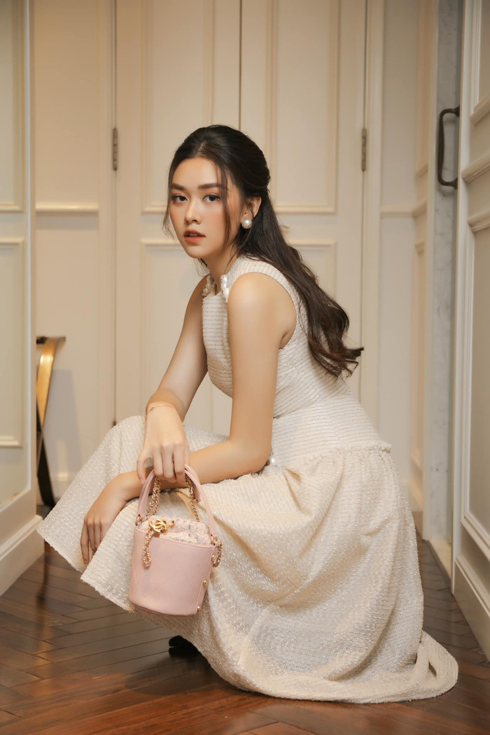 Ngoài ra kiểu tóc này còn giúp nàng Á hậu khoe triệt để đôi khuyên tai to bản mà khi kết hợp cùng chiếc váy trắng và túi xách màu hồng đã đem đến cho cô vẻ ngoài đầy khi chất và thời thượng