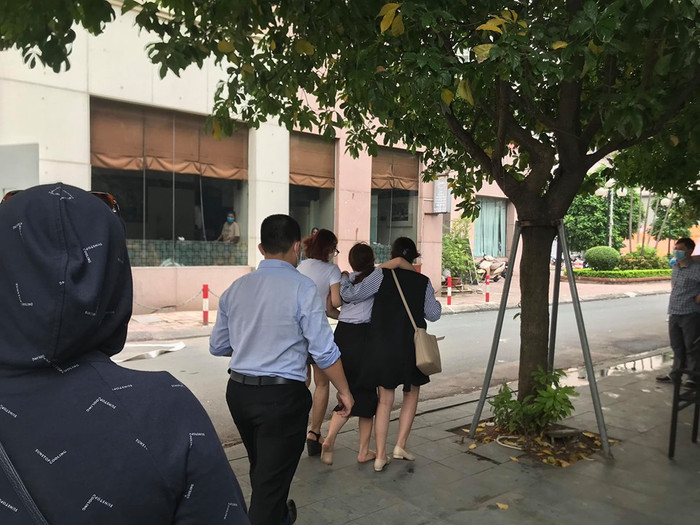 Mẹ cháu bé sốc nặng, được mọi người dìu đi.