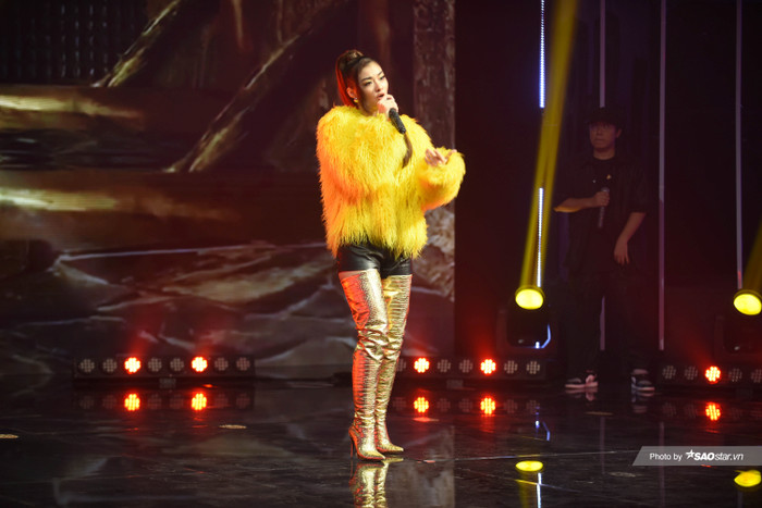 Nàng hậu mix trang phục bên trong là set đồ đen mix cùng bên ngoài là áo lông vũ màu vàng kết hợp với boots cổ cao chói chang 