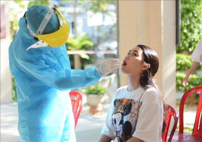 Cán bộ y tế tiến hành lấy mẫu xét nghiệm cho thí sinh dự thi tại điểm thi trường THPT Trần Phú. Ảnh: TTXVN