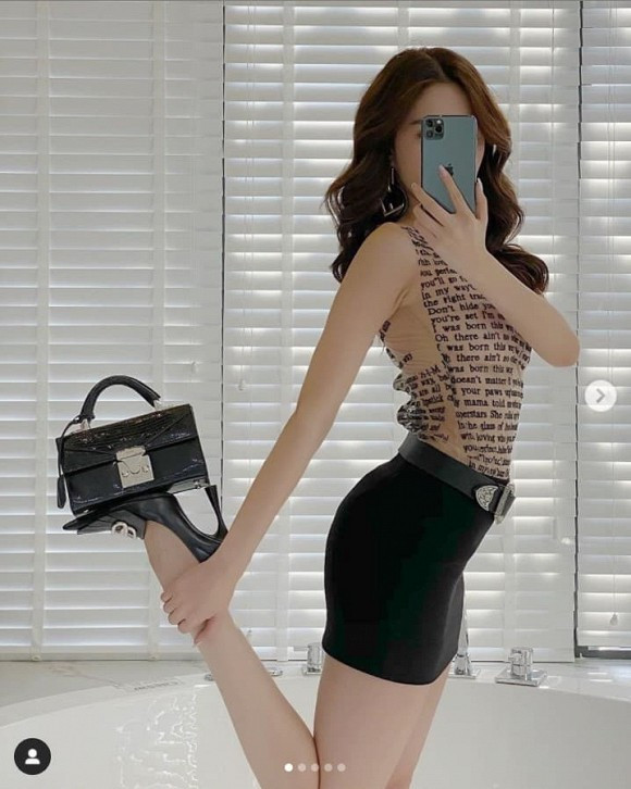 Ngọc Trinh pose dáng đầy điệu nghệ khi co lại một chân và đặt túi lên bàn chân