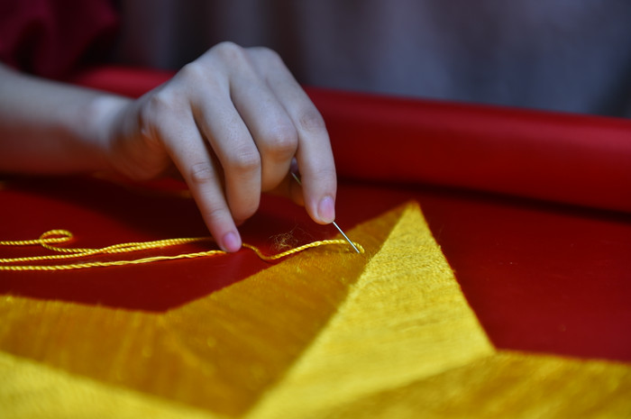 Bà Ngân (54 tuổi) cho biết, thêu cờ bằng tay sẽ tốn nhiều thời gian, công sức hơn. Một lá cờ có khổ lớn có thể phải mất 1 tuần mới hoàn thiện xong phần thêu tay. Mặc dù công nghệ in cho sản phẩm nhanh chóng, thuận tiện hơn rất nhiều nhưng điểm nổi bật của thêu thủ công là sao vàng 5 cánh nổi khối, tỉ mỉ, chi tiết hơn nên dù trải qua nhiều thăng trầm, nghề thêu cờ Tổ quốc bằng tay vẫn không mất đi giá trị.