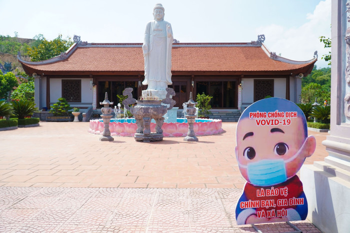 Bên ngoài cổng chùa có biển thông báo mọi người đeo khẩu trang phòng chống dịch.