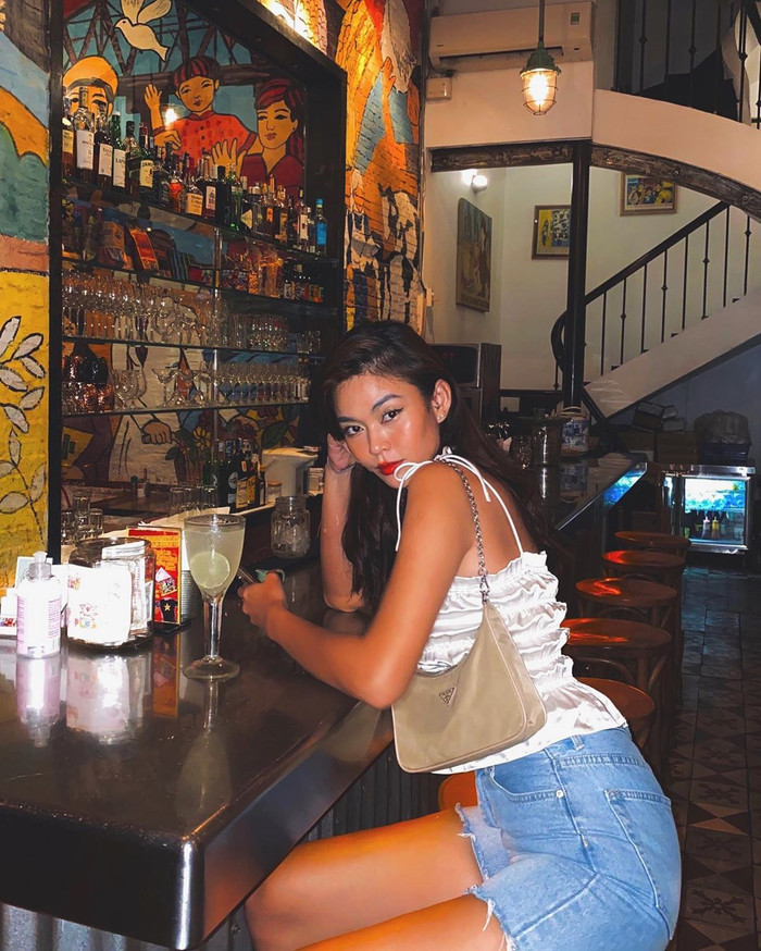 Á hậu Mâu Thủy mang đến một phong cách rất 'chơi' với áo croptop hai dây đi kèm quần short ngắn và túi cặp nách.