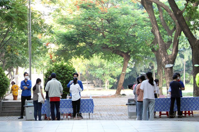 Các thí sinh được kiểm tra thân nhiệt, đổi khẩu trang,... trước khi vào phòng thi. Ảnh: Giang Thanh/Báo Tiền Phong