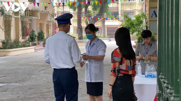 Thí sinh Nguyễn Mạnh Chiến (hiện đang học tập tại Trung tâm đào tạo và bồi dưỡng nghiệp vụ Cảnh sát biển) được đo thân nhiệt và sát khuẩn tay trước khi vào phòng thi.&nbsp;Ảnh: VOV