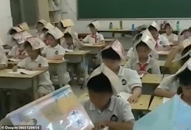 Giáo viên bắt học sinh đội sách lên đầu để 'sửa tư thế'.