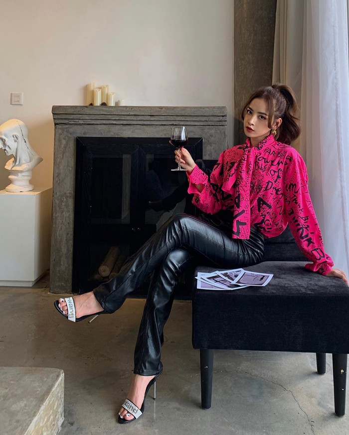 Quần da ống đứng đi cùng sơ-mi hồng hot pink, tạo thành combo nổi bật và cực kỳ sang chảnh. 