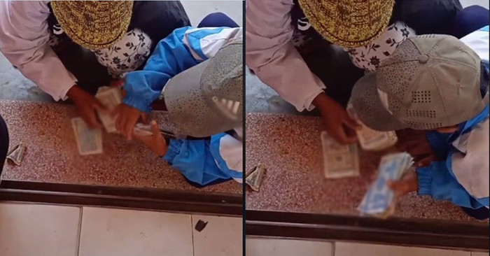 Người mẹ và cậu con trai ngôi đếm từng đồng tiền lẻ để gom tiền, mua điện thoại cho chị lớn chuẩn bị vào lớp 12. Ảnh cắt từ clip