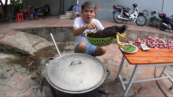 Hưng Vlog đã trực tiếp bắt gà và cho nguyên con gà chưa được sơ chế vào nồi cháo đang sôi. (Ảnh: Hưng Troll)