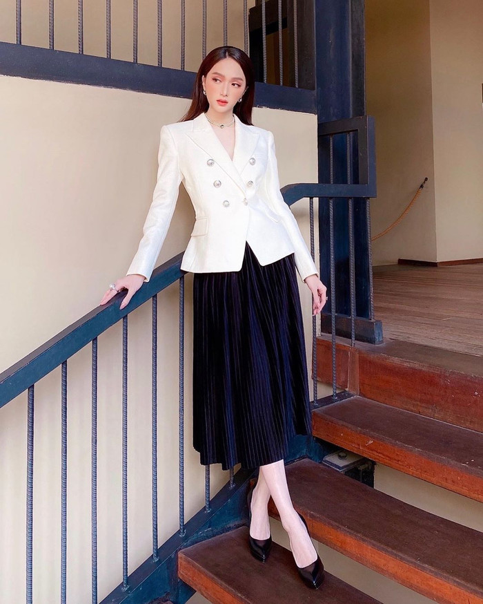 Ghép đôi blazer trắng và chân váy maxi đen theo phong cách tối giản, Hương Giang mang giày đen cùng tông cho bộ cánh thêm thanh lịch, tinh tế.