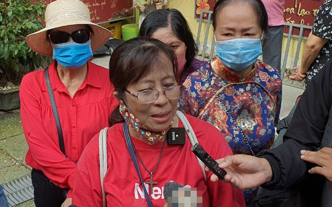 Bà Vân xúc động khi tìm được tro cốt của chồng. Ảnh: Tiền Phong