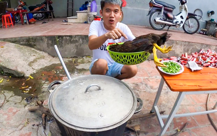 Hưng Vlog trong video nấu nồi cháo trắng với con gà còn nguyên lông bị cộng đồng mạng lên án gay gắt. (Ảnh: Hưng Troll)
