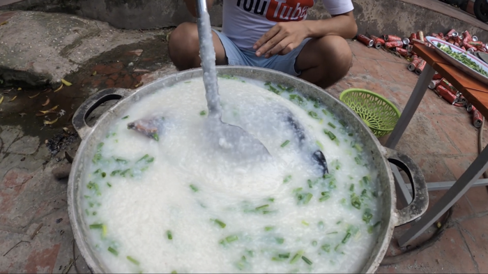 Hình ảnh con gà nguyên lông sau khi được thả vào nồi cháo. (Ảnh: Hưng Troll)