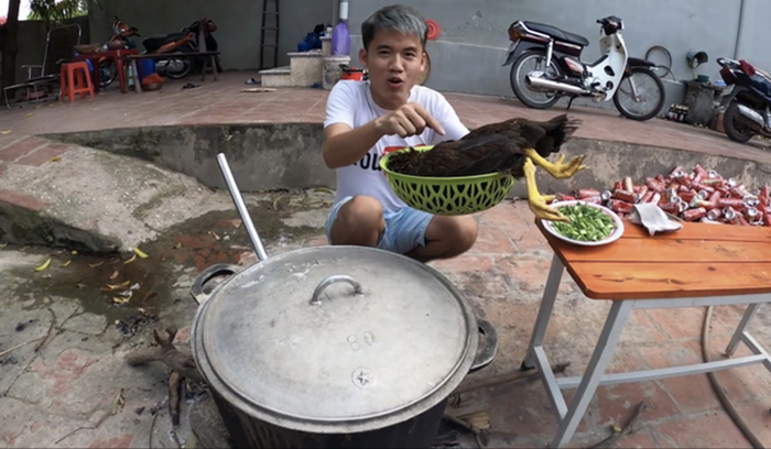 Hưng Vlog cùng con gà được chuẩn bị để cho vào nồi cháo. (Ảnh: Hưng Troll)