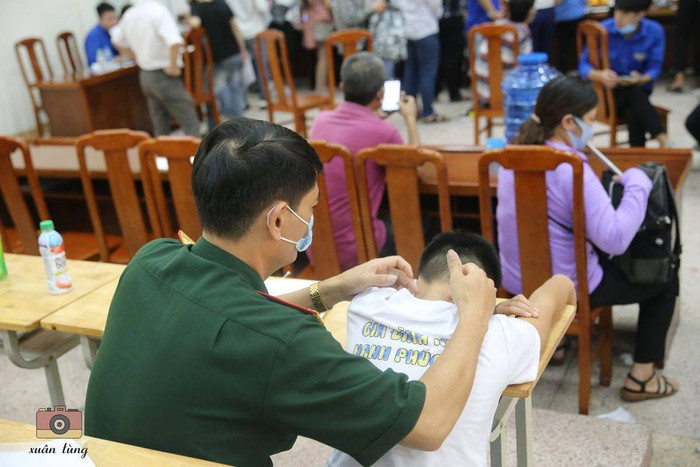 Bố động viên, xoa bóp khi thấy cậu con trai khá mệt trong buổi nhập học. Ảnh: Xuân Tùng