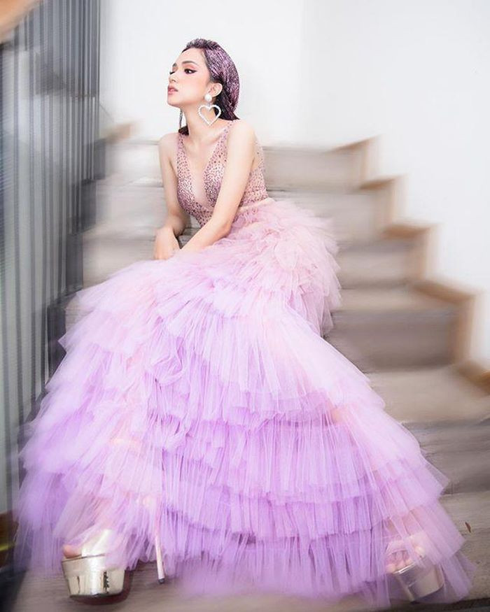 Cũng là kiểu váy công chúa nhưng Hoa hậu Hương Giang lại mang đến một vẻ ngoài gợi cảm, quyến rũ khi chọn chiếc váy voan màu tím ombre có thiết kế cầu kỳ. Phần thân váy được đính pha lê lấp lánh và chân váy thì được kết từ vải voan mỏng xếp lớp tỉ mỉ.