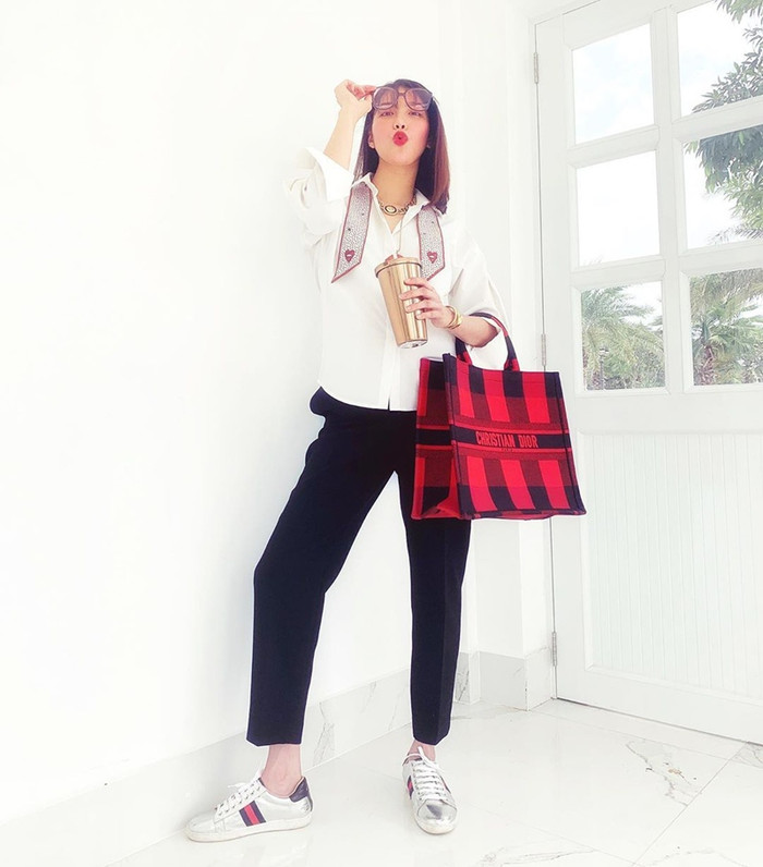 Lan Khuê sử dụng kiểu áo có cravat khoác hờ hững, bởi phần trên đã nổi bật nên chỉ cần phối cùng quần tây là có ngay set đồ ưng ý. 