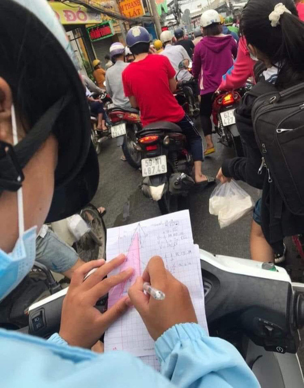 Nữ sinh làm bài tập trong lúc đến trường. Ảnh: Làng sinh viên