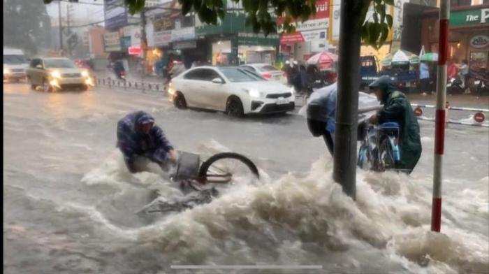 Bất chấp dòng nước chảy xiết trong cơn mưa lớn để đạp xe về nhà, nhóm học sinh ngã nhào xuống đường khiến nhiều người thót tim Ảnh 3