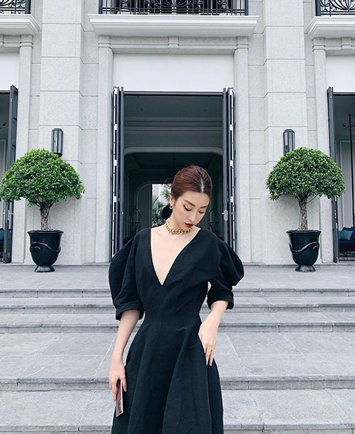 Chiếc váy đen tay phồng, có đường xẻ ngực sâu mang lại độ thanh nhã cho người mặc. 