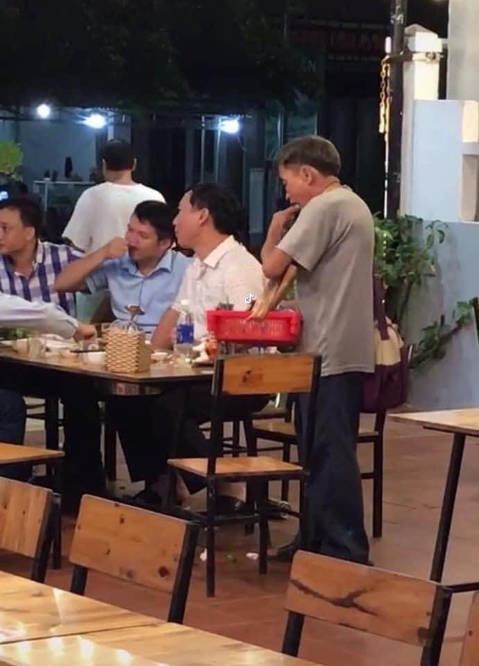 Cụ ông thoải mái nhận đĩa thịt được một thực khách mời. 