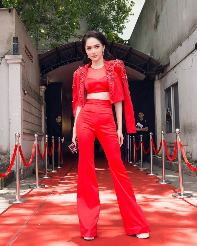 Hoa hậu chuyển giới vô cùng nổi bật trong buổi ghi hình Siêu mẫu Việt Nam 2018 với suit đỏ rực. Set đồ nhấn nhá thêm loạt họa tiết đính kết cầu kỳ ở vai và cổ áo. Hơn nữa, chiếc bra-top lưới gợi cảm bên trong cũng gây chú ý giới mộ điệu. Người đẹp 29 tuổi không quên kết hợp cùng giày cao chót vót trên thảm đỏ. 