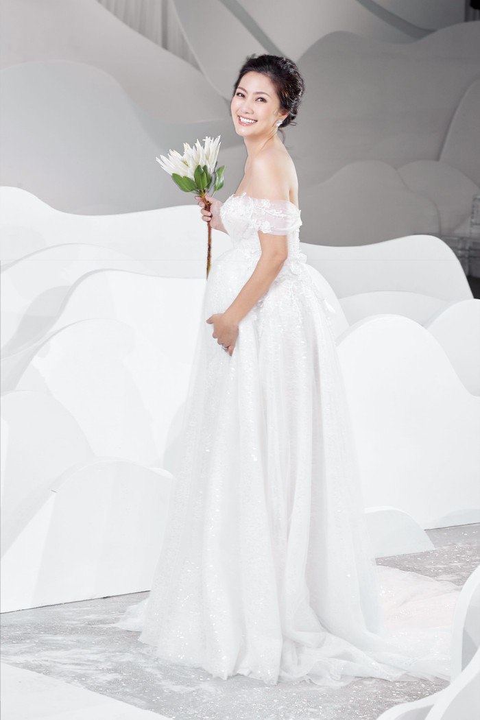 Nữ diễn viên chọn kiểu váy trắng tinh khôi với form váy suôn dài trễ vai khoe xương quai xanh gợi cảm