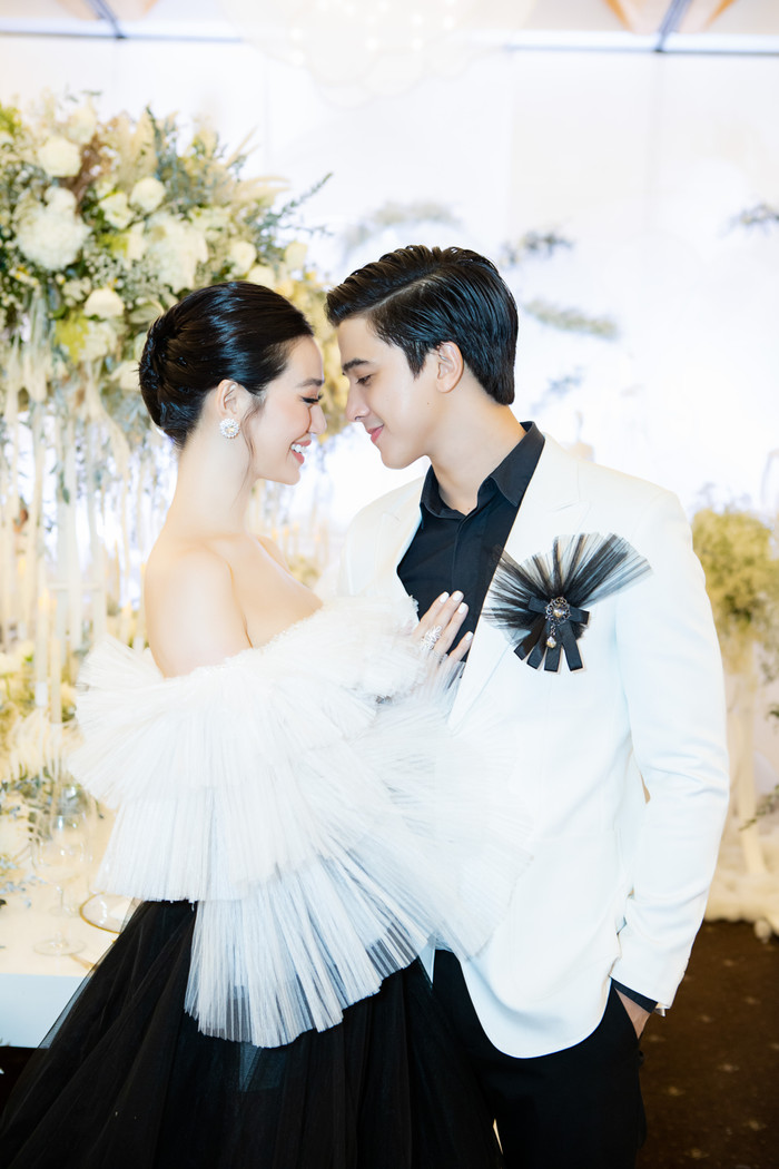 “Mỹ nhân Sài Thành' diện đầm dạ hội cầu kì với phần cổ thuyền gợi cảm, cùng phần tay voan xếp tầng và phần chân váy bồng bềnh. Sánh đôi bên Khánh My là bạn trai Tiến Vũ với vest trắng lịch lãm. 