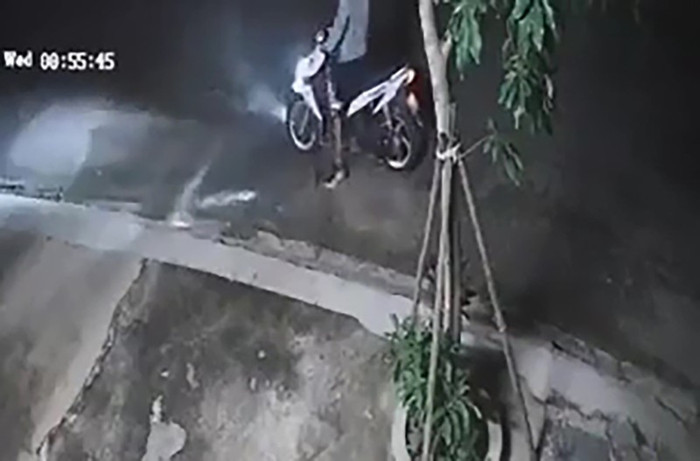 Tên cướp tạt nước cay vào mặt anh T. rồi lấy xe rời khỏi hiện trường. Ảnh cắt từ clip
