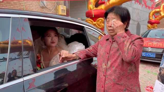 Bà nội nắm lấy tay cháu gái, một tay lặng lẽ lau nước mắt khi cháu lên xe hoa. 