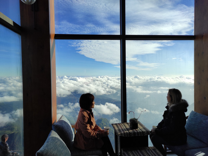 Nhiều người ngồi bên cốc trà nóng ngắm mây. Mùa săn mây, du khách nhiều người mong được nhìn thấy hiện tượng phát quang trên khu vực đỉnh, ngay tại vị trí tượng Quan Thế Âm Bồ Tát hay Kim Sơn Bảo Thắng tự. 