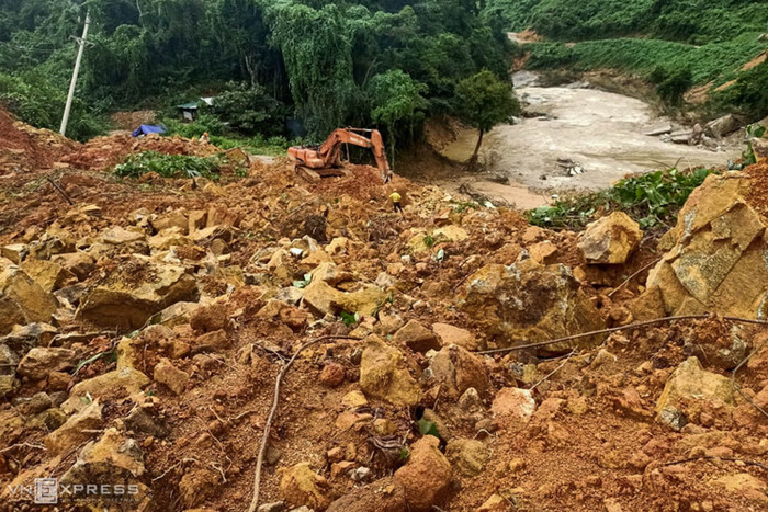 Sau khi nước lũ rút, máy ủi tiếp tục tìm kiếm các nạn nhân mất tích trong đống đổ nát. Ảnh: VNE