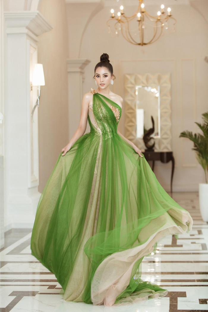 Vẫn chọn kiểu tóc búi cao, nhưng Tiểu Vy mạnh dạn chơi nổi với bộ váy màu xanh lá cây rất kén màu da. Với vẻ đẹp tươi trẻ của mình, Hoa hậu Việt Nam 2018 tung bay, bồng bềnh trên nền chất liệu voan hút mắt.