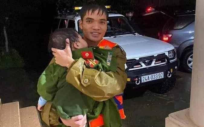 Xúc động hình ảnh chiến sĩ công an cởi áo quân phục ủ ấm em bé vừa được giải cứu khỏi xe khách bị lũ cuốn trôi Ảnh 2