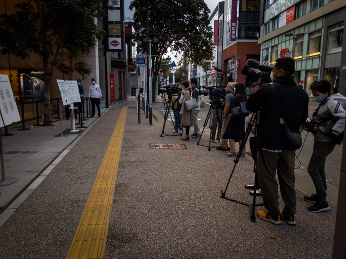 Các phóng viên đứng trước Apple Store Fukuoka, Nhật còn đông hơn cả người xếp hàng mua iPhone 12. (Ảnh: @Aki_pic / Twitter )