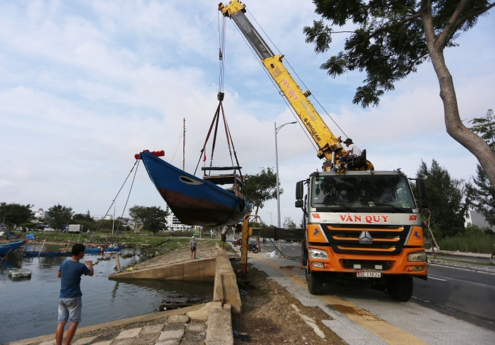 Ngư dân cẩu tàu thuyền lên bờ tránh bão. Ảnh: VietNamNet