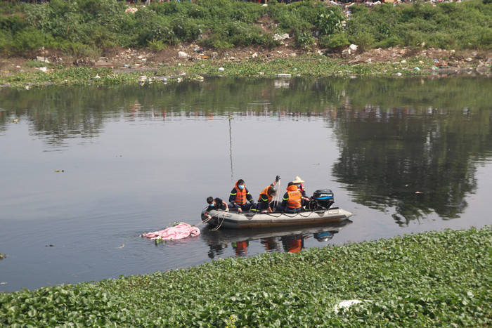 Lực lượng công an đưa thi thể nạn nhân vào bờ.