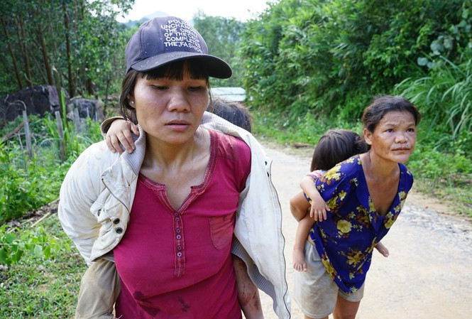 Chị Trần Thị Diệu ôm đứa con gái tháo chạy khỏi nơi sạt lở. Ảnh: Hoài Văn/Tiền Phong
