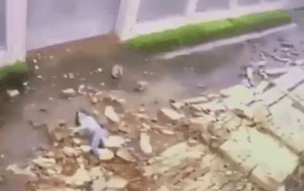 Clip: Đang đi trên đường, cô gái bất ngờ bị bức tường lớn đổ sập đè trúng người Ảnh 2